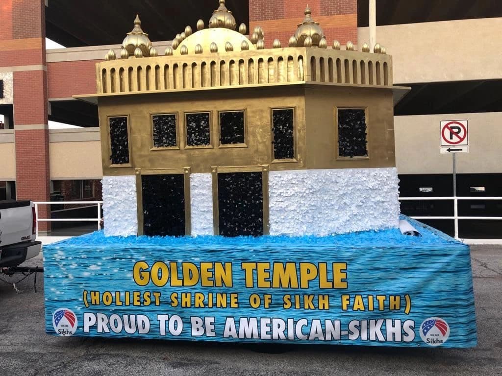 The sangat's Golden Temple parade float — a gold model on a blue banner reading 'Golden Temple, holiest shrine of Sikh faith — proud to be American Sikhs'