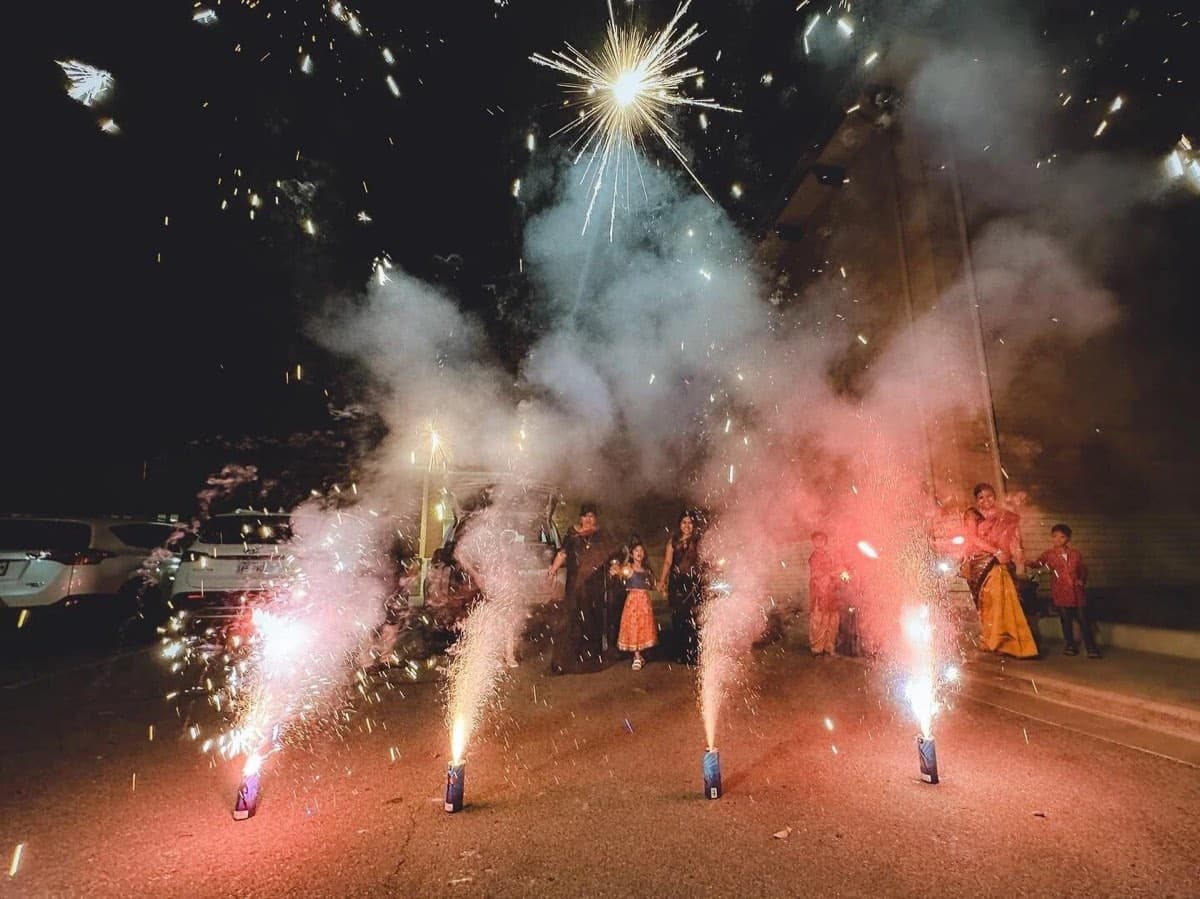 Families lighting fountains and sparklers in the parking lot at KCBA's Kali Puja 2022