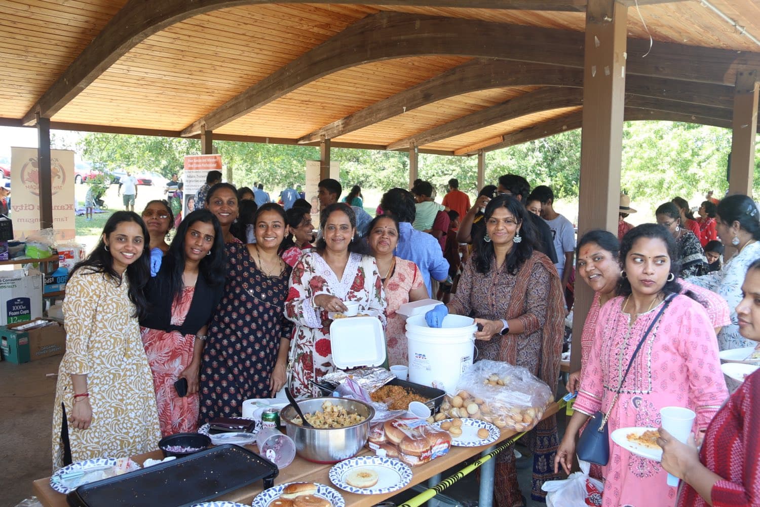 Volunteers serving food under the shelter at the KCTS summer picnic, 2024