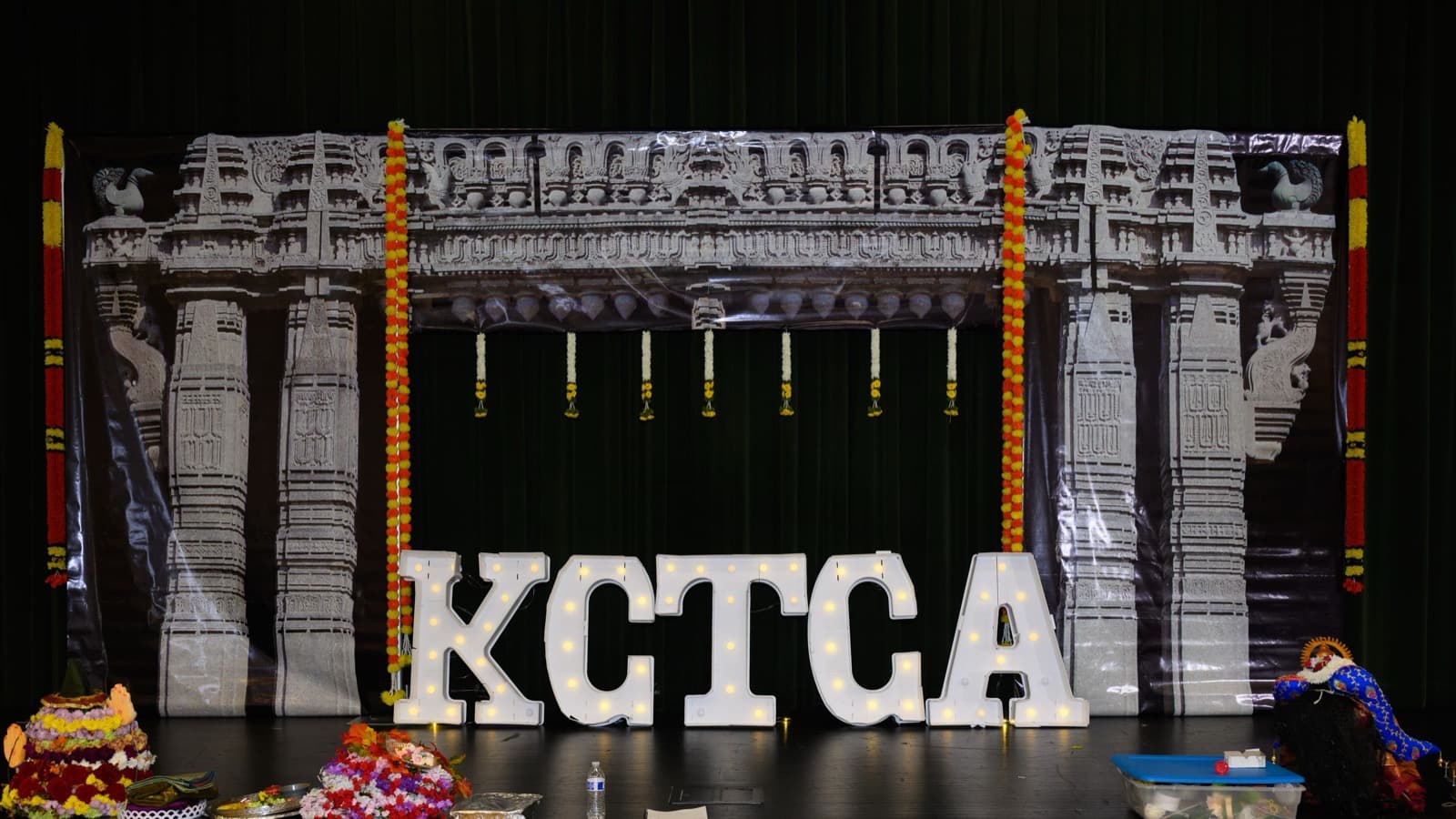 KCTCA marquee letters and Bathukamma flower stacks in front of a Kakatiya Kala Thoranam backdrop on the Bathukamma 2024 stage in Overland Park